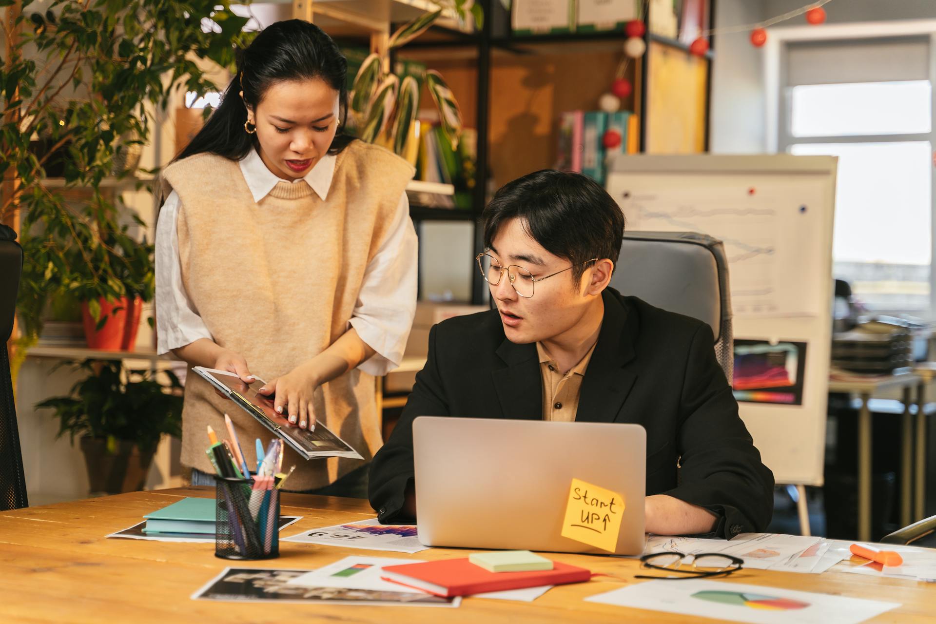 A man and woman engage in a business discussion at a startup office, focusing on teamwork and collaboration.