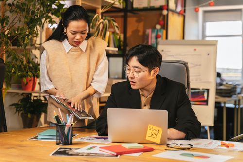 Free A man and woman engage in a business discussion at a startup office, focusing on teamwork and collaboration. Stock Photo