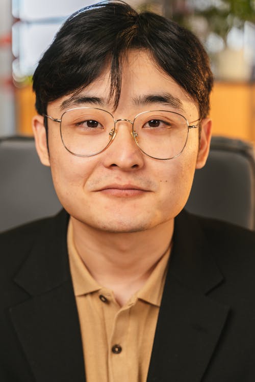 Close-Up Photo of a Man Wearing Eyeglasses Looking at the Camera