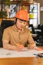 Man in Brown Hoodie Wearing Orange Helmet