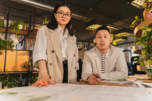 Focused professionals working together in a modern office setting with charts and documents.