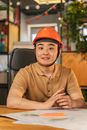 Man Wearing a Hard Hat Sitting in Front of a Desk