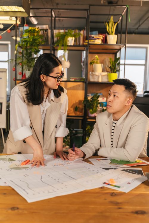 Free Colleagues engaged in a strategic planning session in a modern office setting. Stock Photo