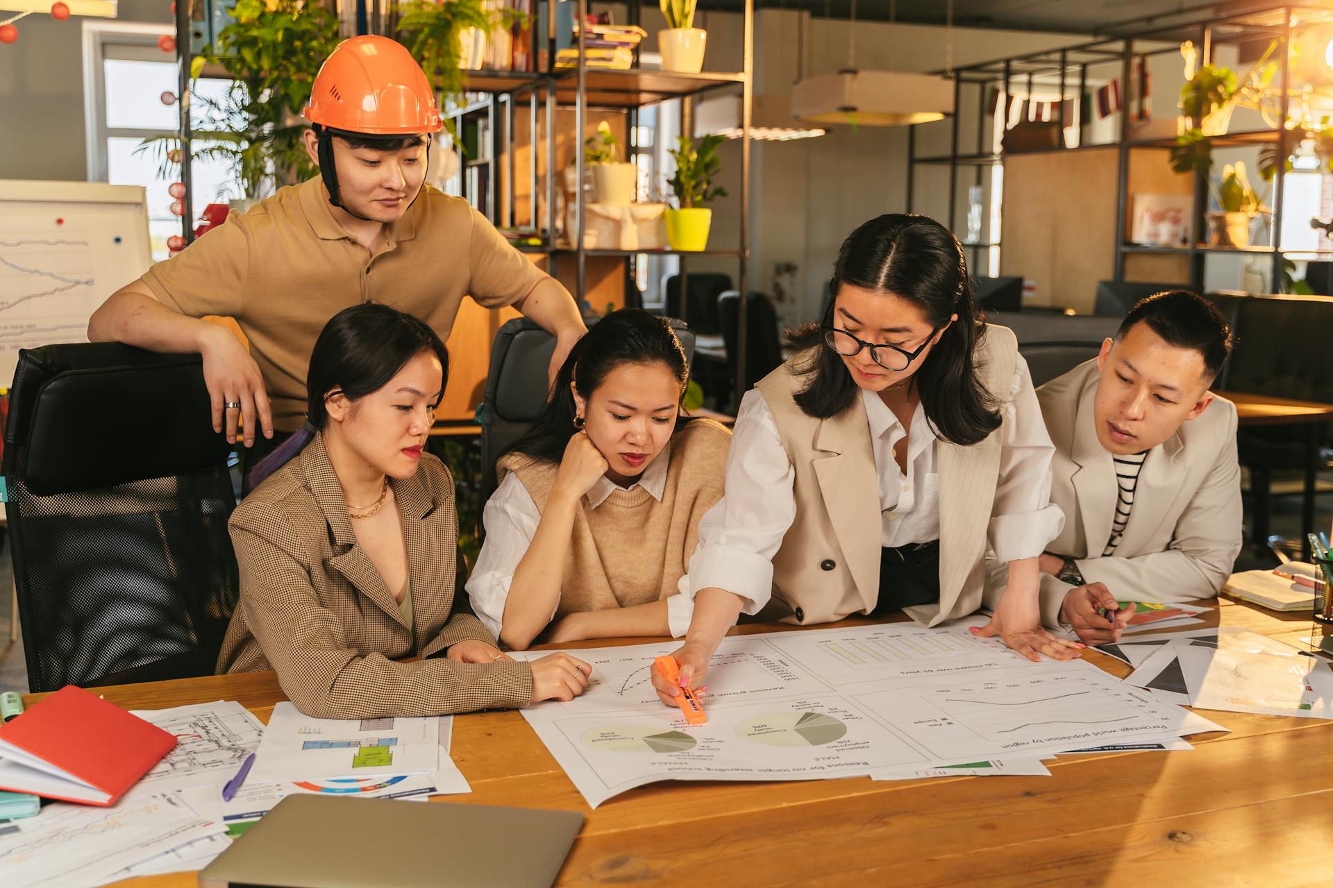 A diverse team of professionals working together on architectural plans in a modern office setting.