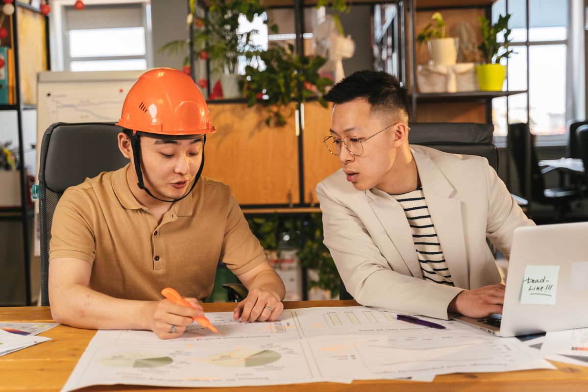 Construction team comparing website architecture options with a sitemap diagram
