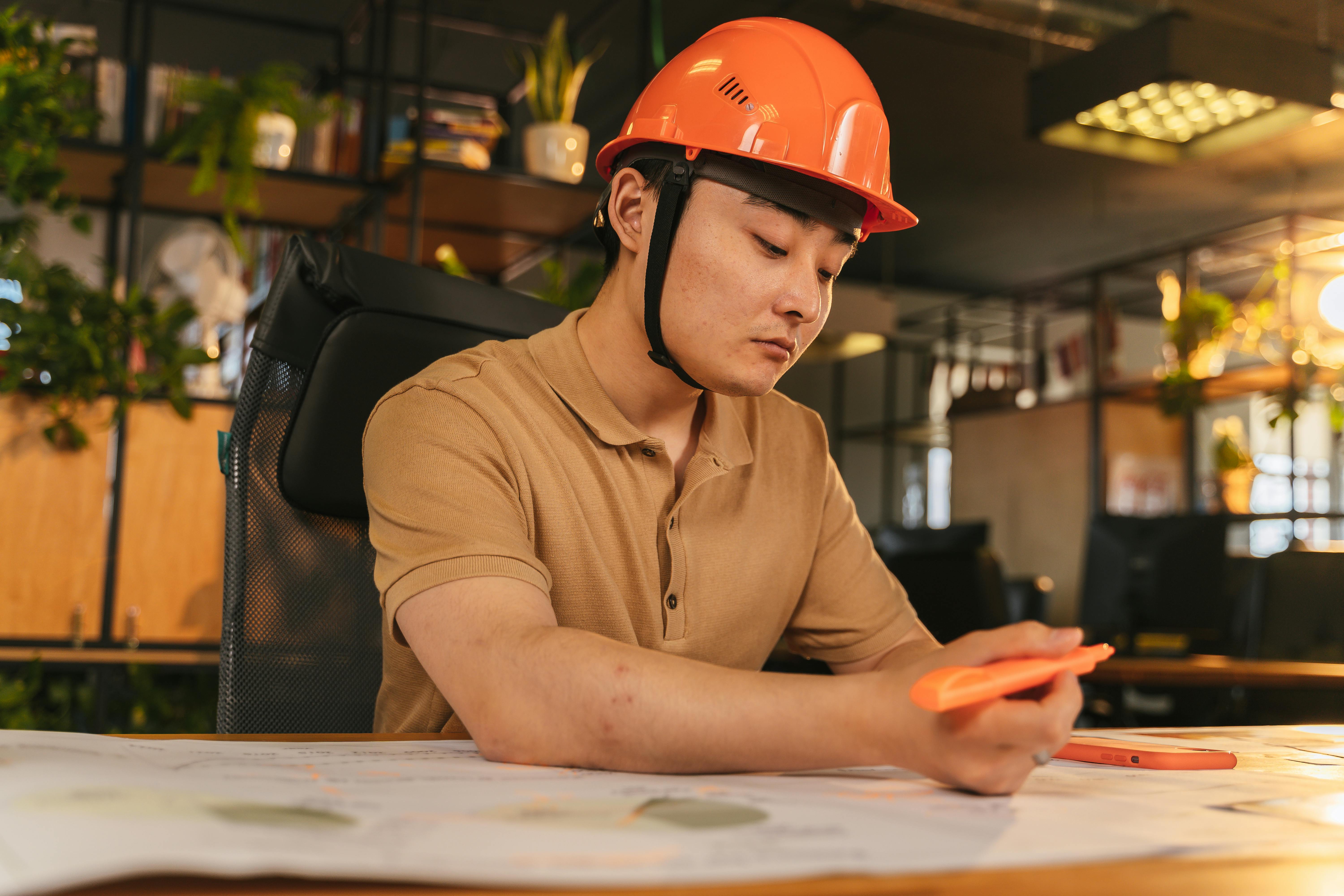 Hollanda'da kariyerine yeni başlayan genç bir mühendisin modern bir ofis ortamında çalışırken çekilmiş, profesyonel başarıyı ve fırsatları temsil eden fotoğrafı.
