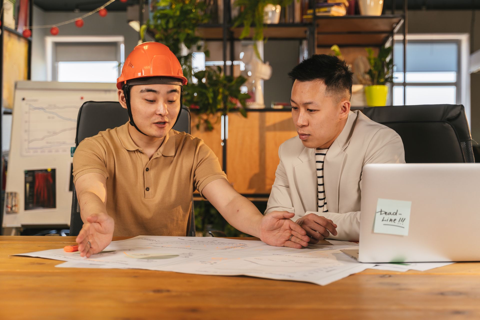 Two engineers discussing project plans in a modern office setting, emphasizing teamwork and collaboration.