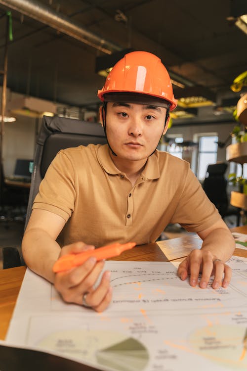 Architect in Safety Helmet over Blueprint