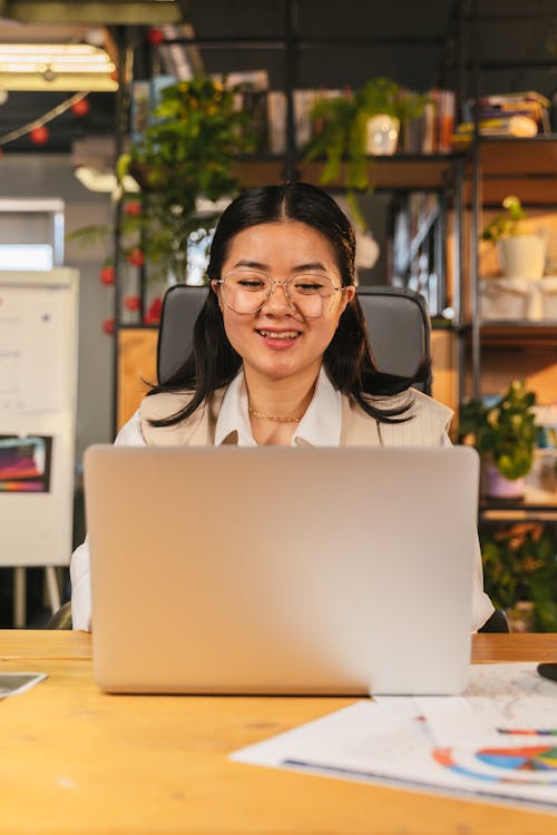 A Woman Looking at Her Laptop while Wearing Eyeglasses