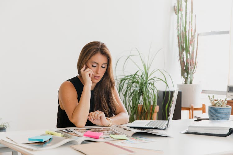 A Woman Looking At The Time While Talking On The Phone