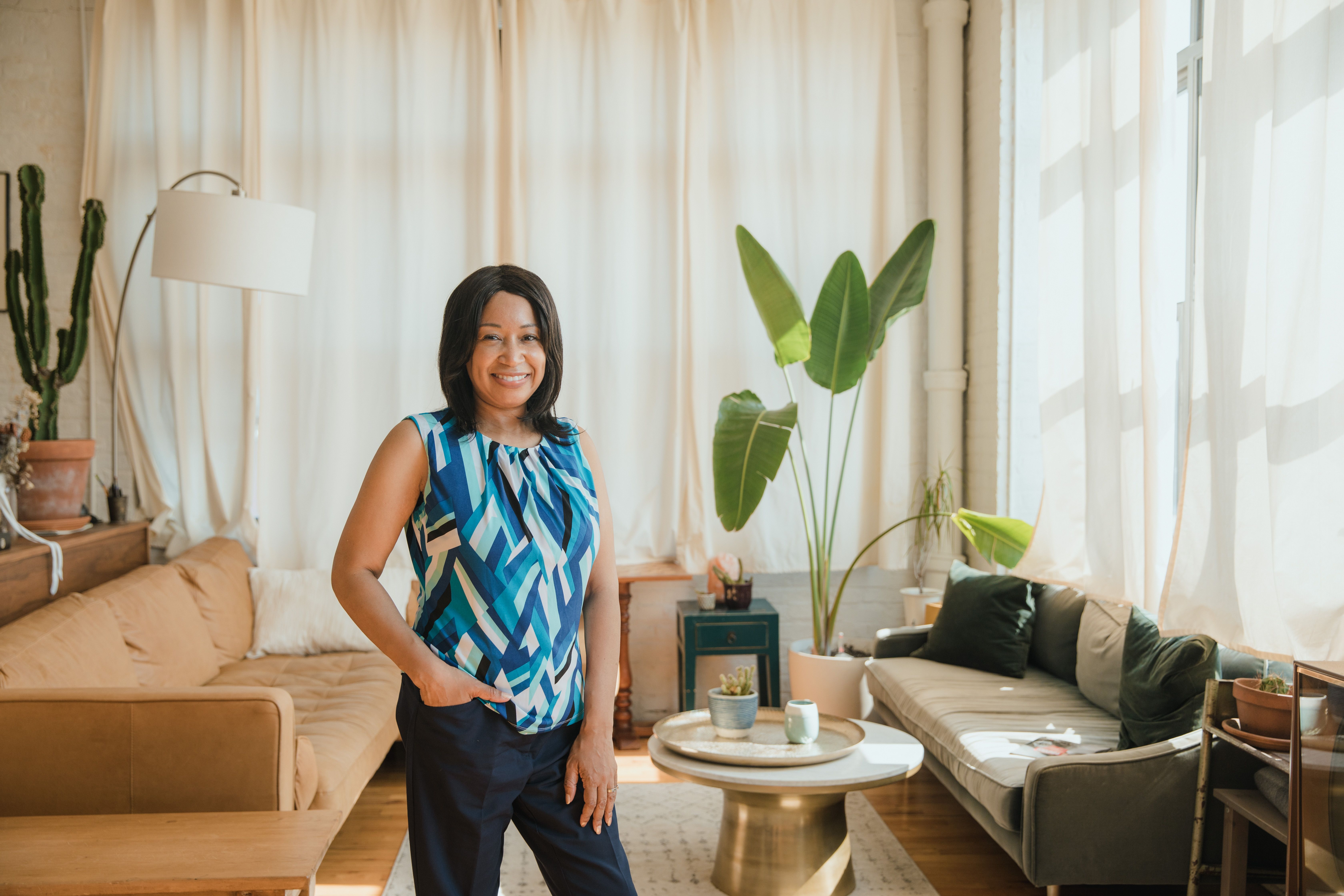 A host standing in her sunlit living room — photo by RDNE Stock project on Pexels