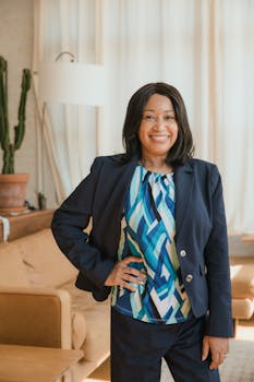 Professional woman in corporate attire standing confidently in an office environment.