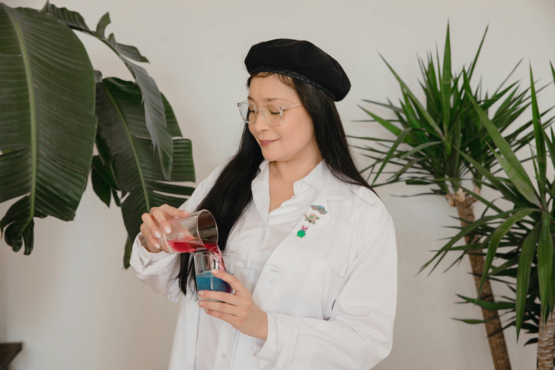 Une femme en robe blanche mélangeant des produits chimiques liquides