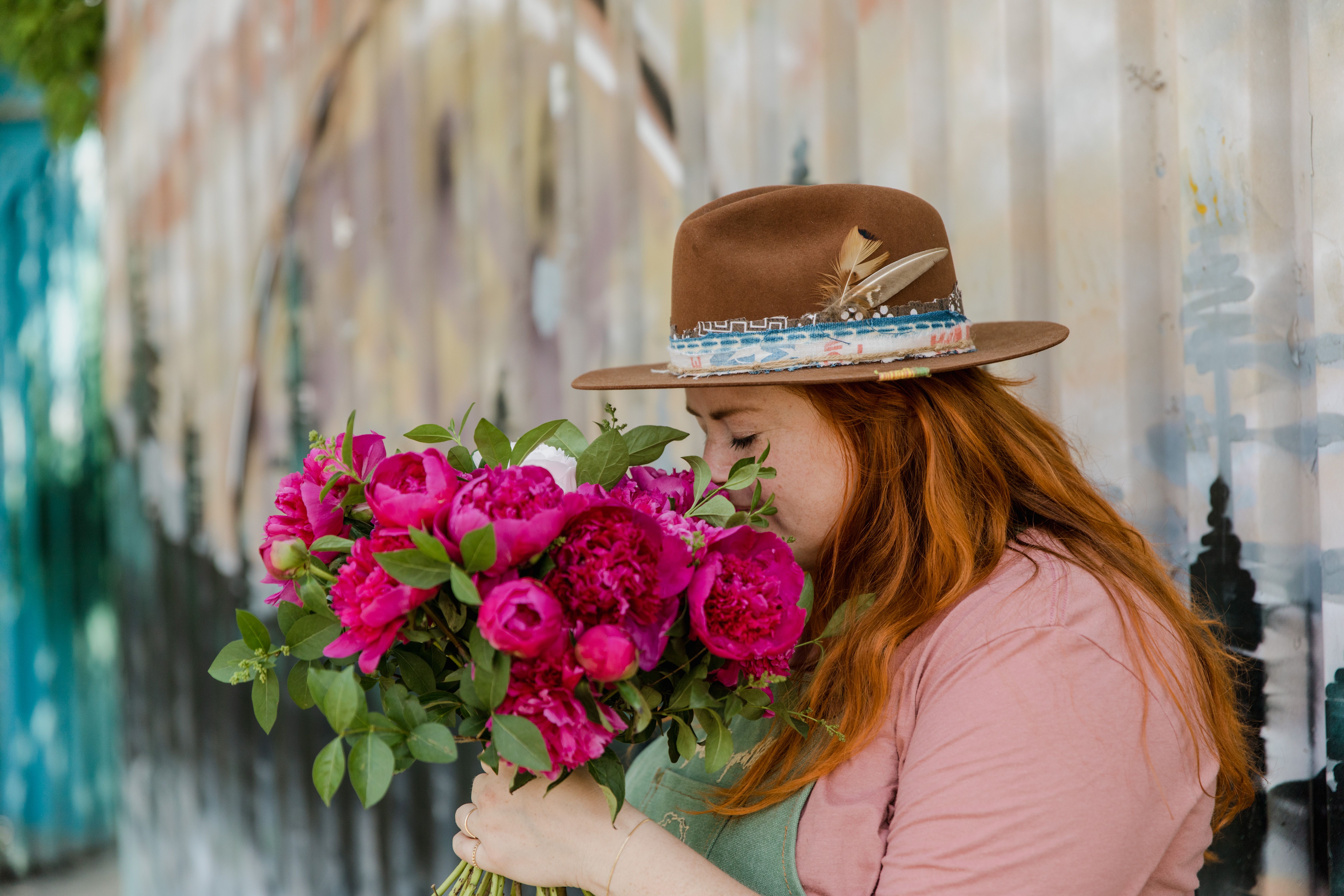Woman in Pink Shirt Wearing Brown Hat Holding Pink Flowers · Free Stock ...