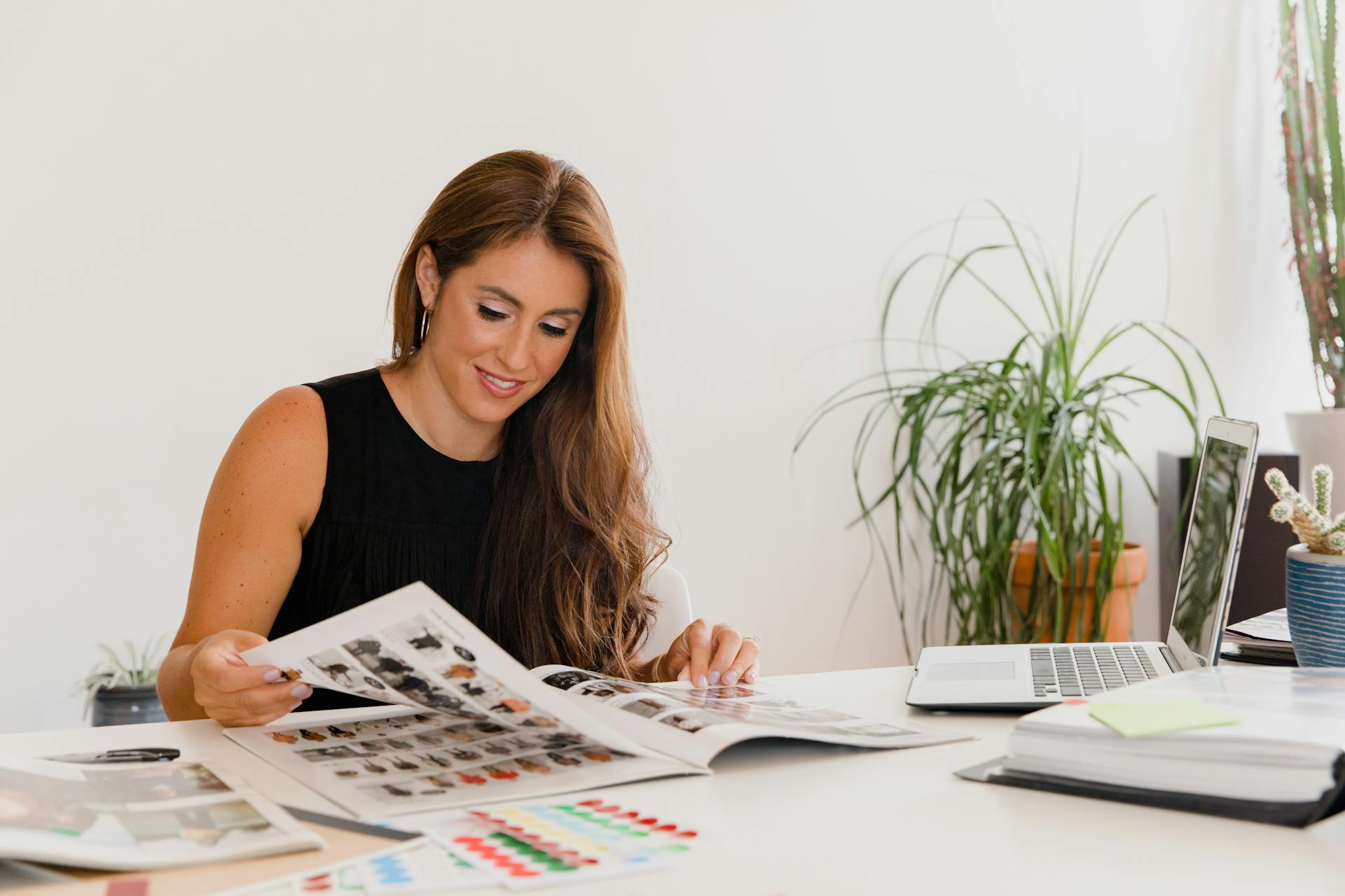 Businesswoman analyzing design portfolio in modern office setting.