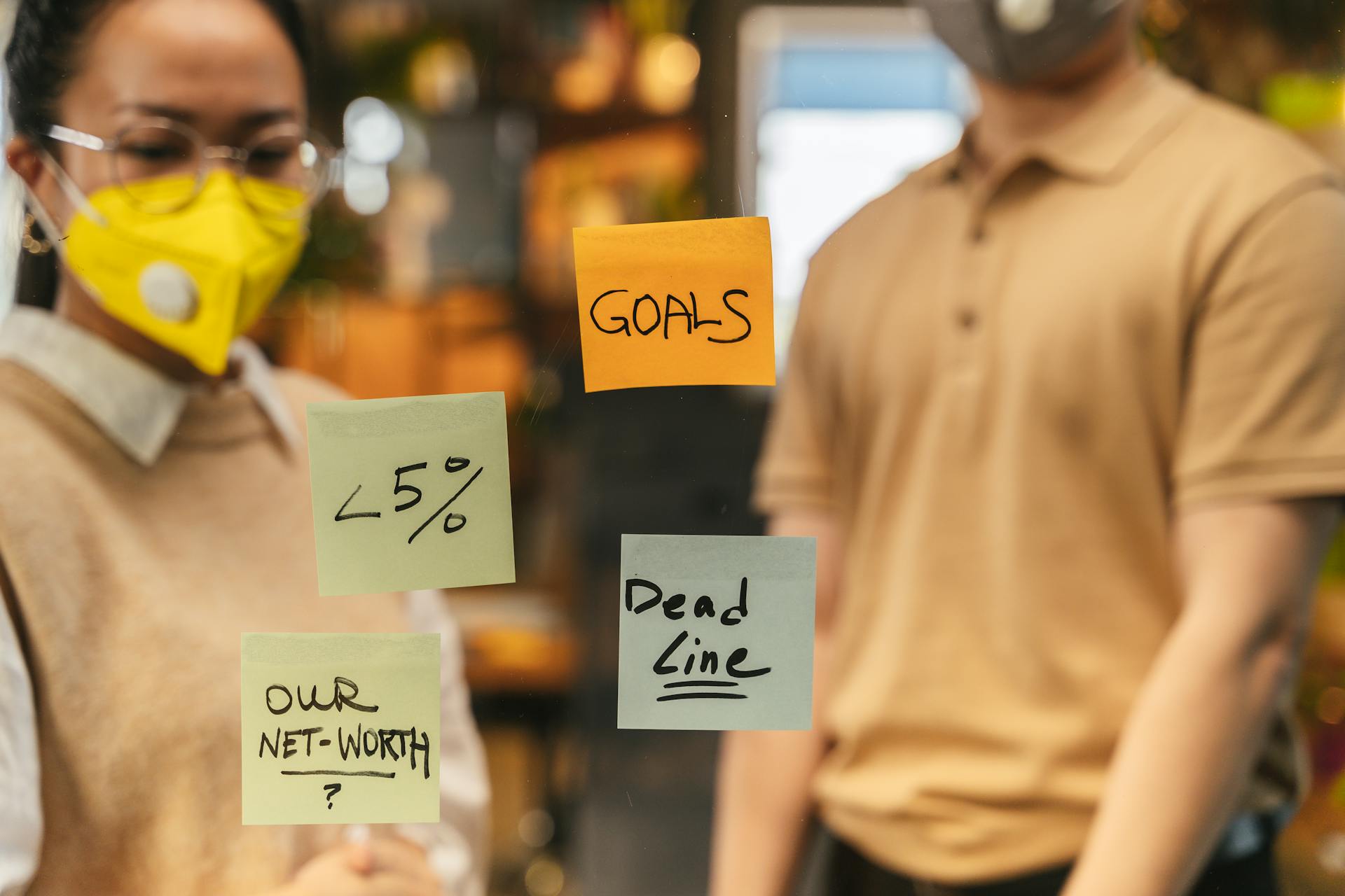 Office scene showcasing goals and deadlines on sticky notes during a brainstorming session.