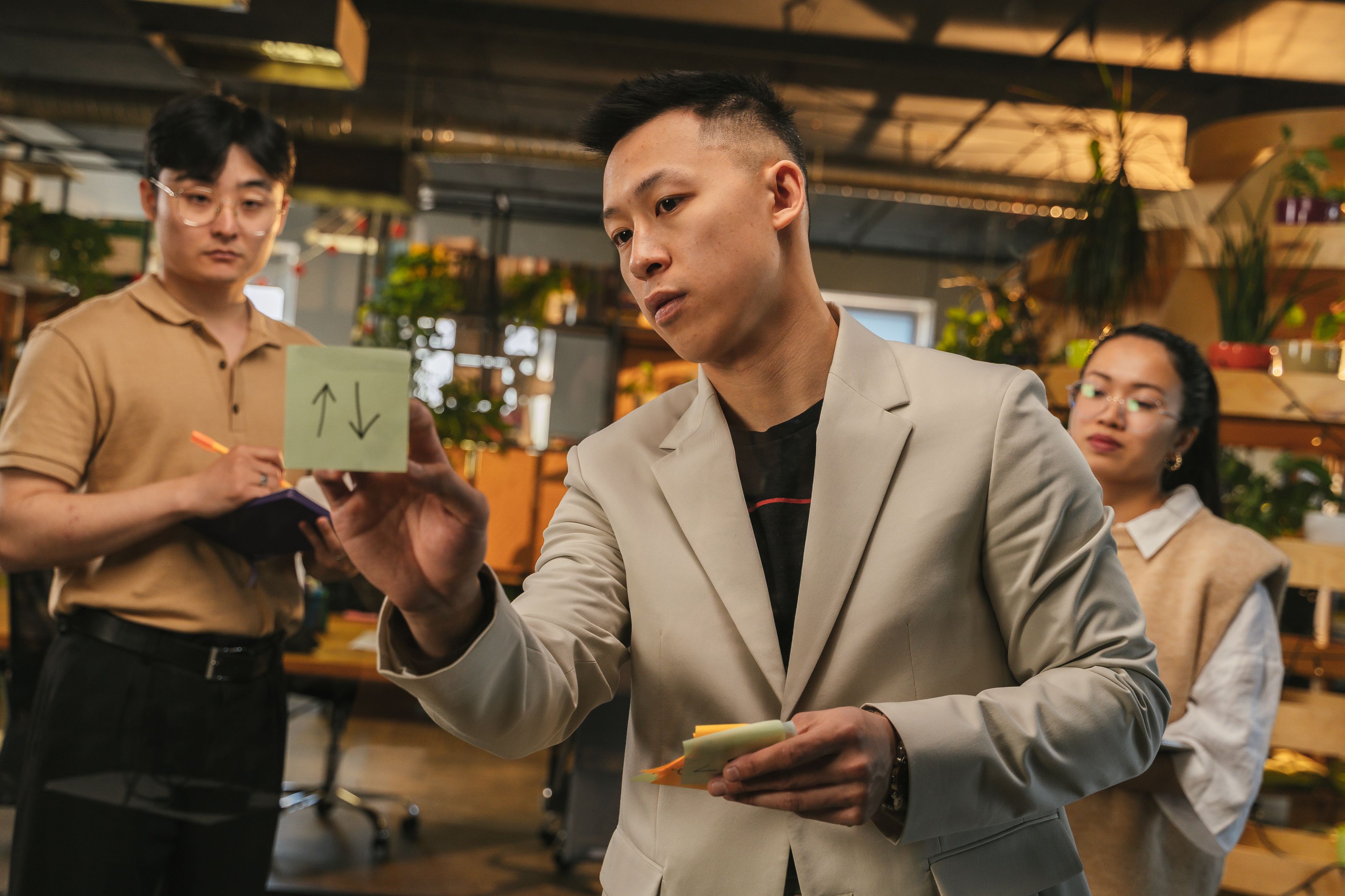 Team brainstorming ideas with sticky notes in a modern office setting.