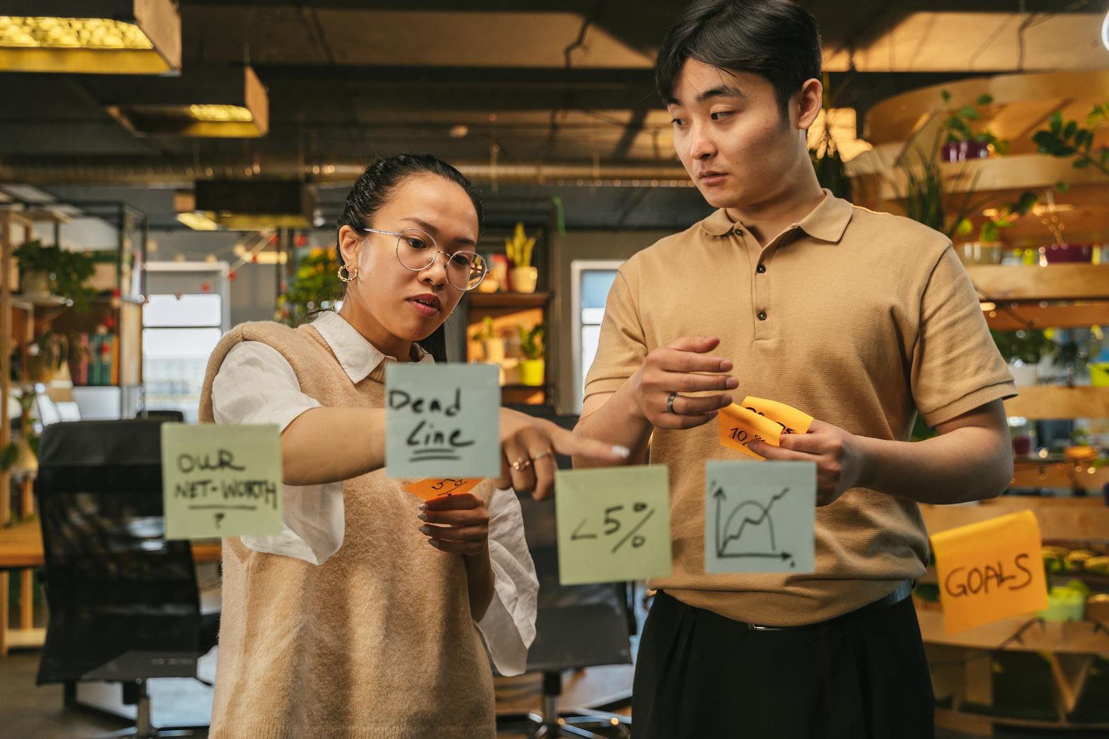 Business team using sticky notes to shortlist options on a planning wall