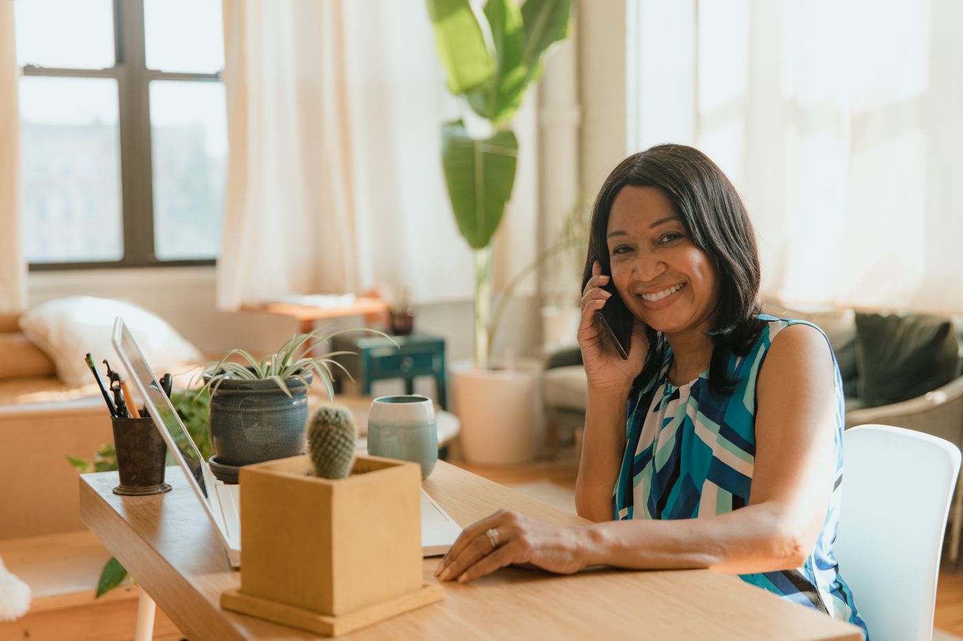 South African consumer using a laptop and mobile phone at home to review an online personal loan