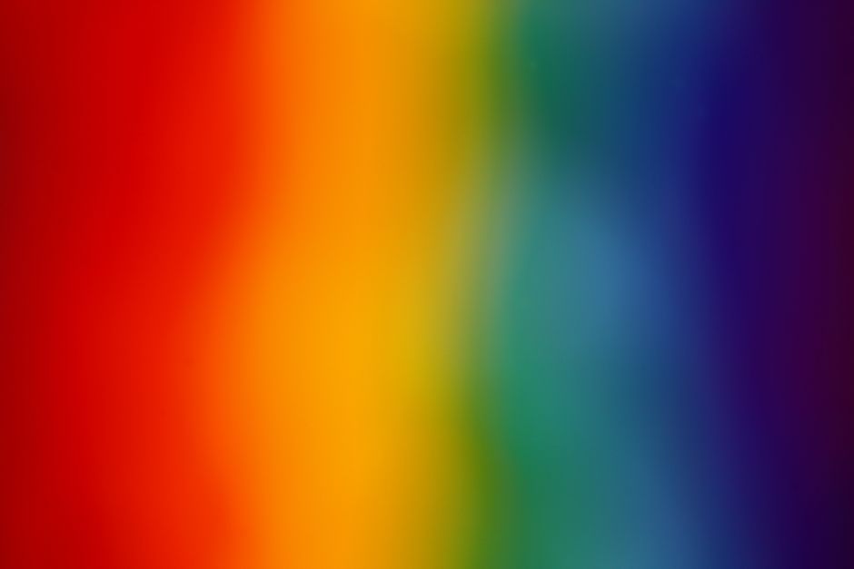 A colorful abstract gradient background featuring a vibrant rainbow spectrum.