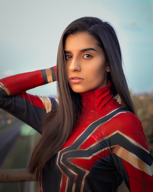 Gentle model in superhero costume with straight hair on bridge