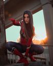 Model in superhero suit on bridge fence in evening