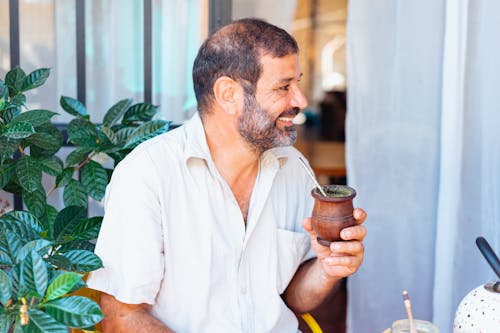 A Man Holding a Wooden Cup
