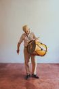 Man in Brown Vest and White Pants Playing Drum