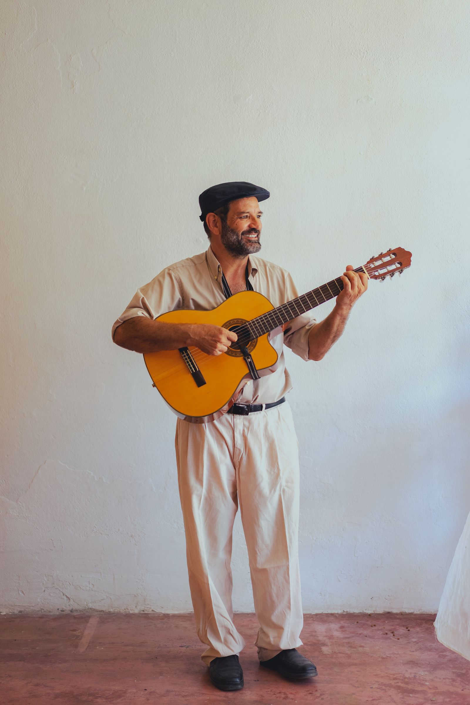 Smiling folk musician playing an acoustic guitar