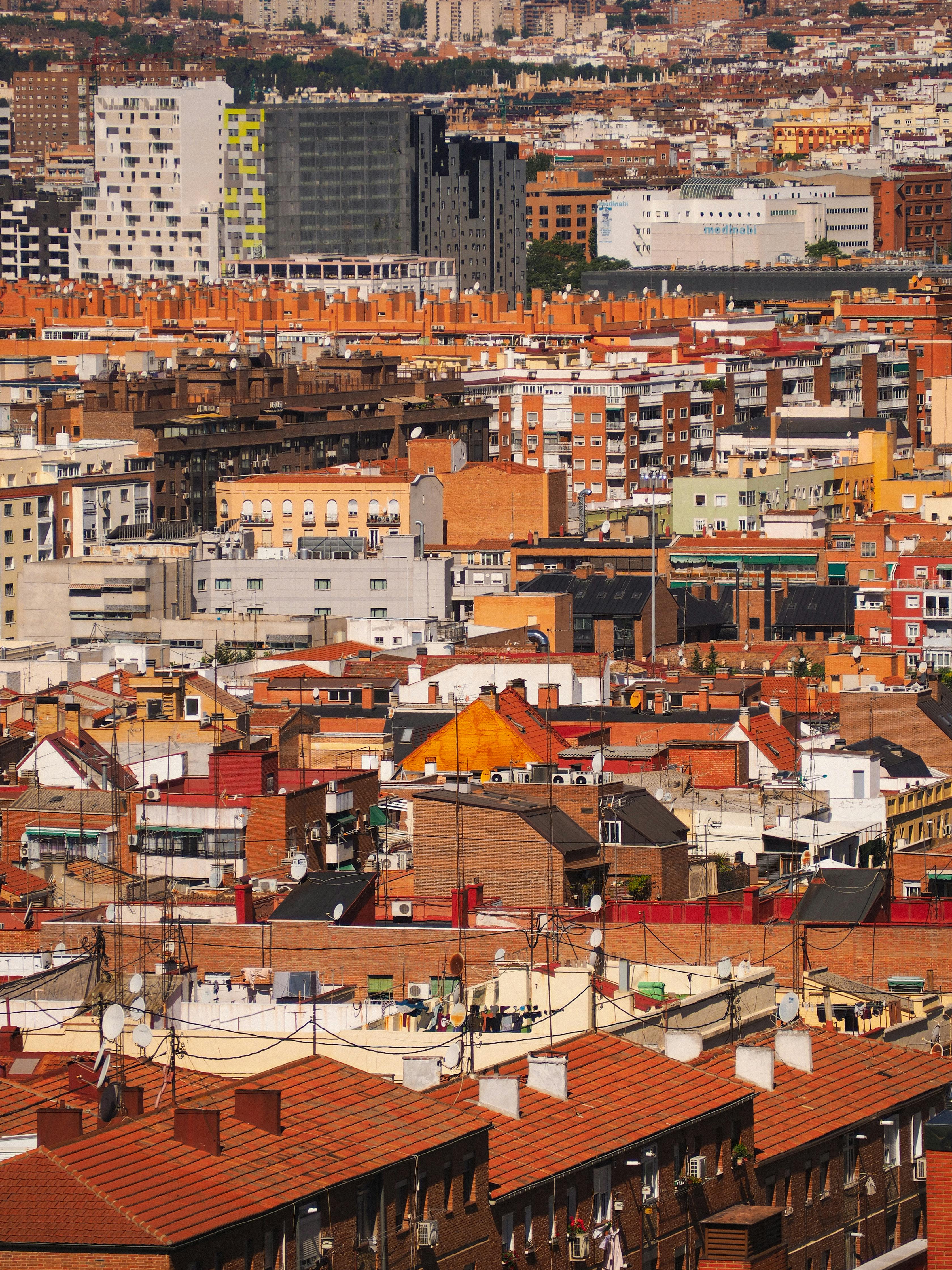 Aerial view of a colorful urban cityscape showcasing diverse architecture under clear skies.