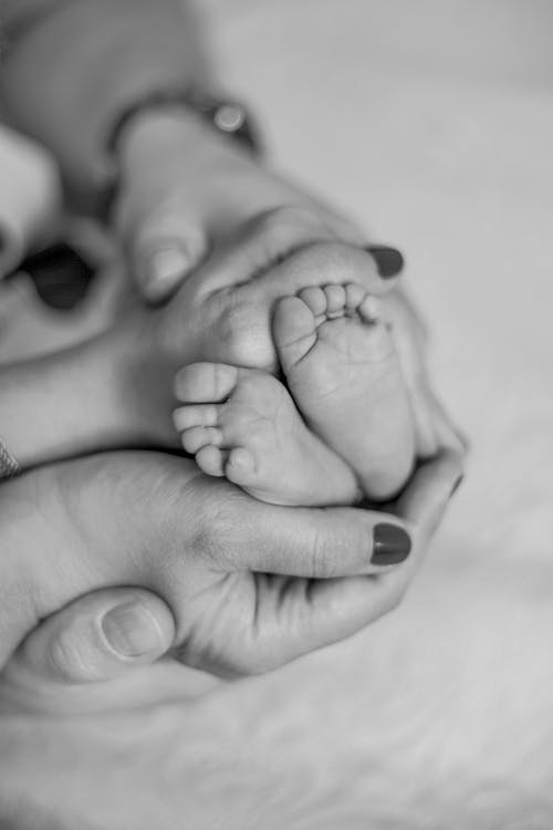 Close-Up Shot of Parents Holding Their Newborn Baby's Tiny Feet