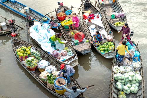 People Riding on Boats Selling Fruits and Vegetables