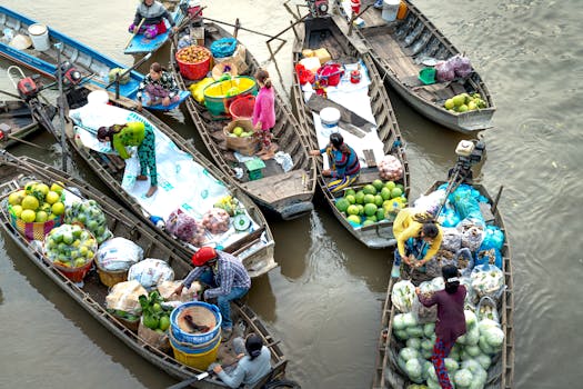 Colorful scene at an Asian floating market with boats filled with fresh fruits and vegetables.