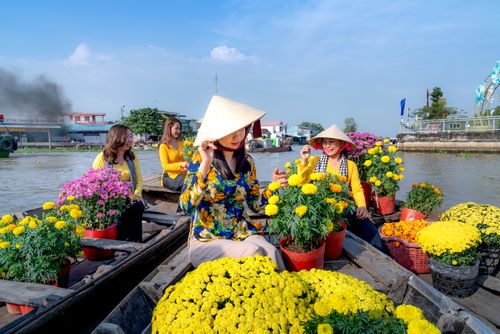 Free Women selling vibrant flowers at a traditional Vietnamese floating market. Stock Photo