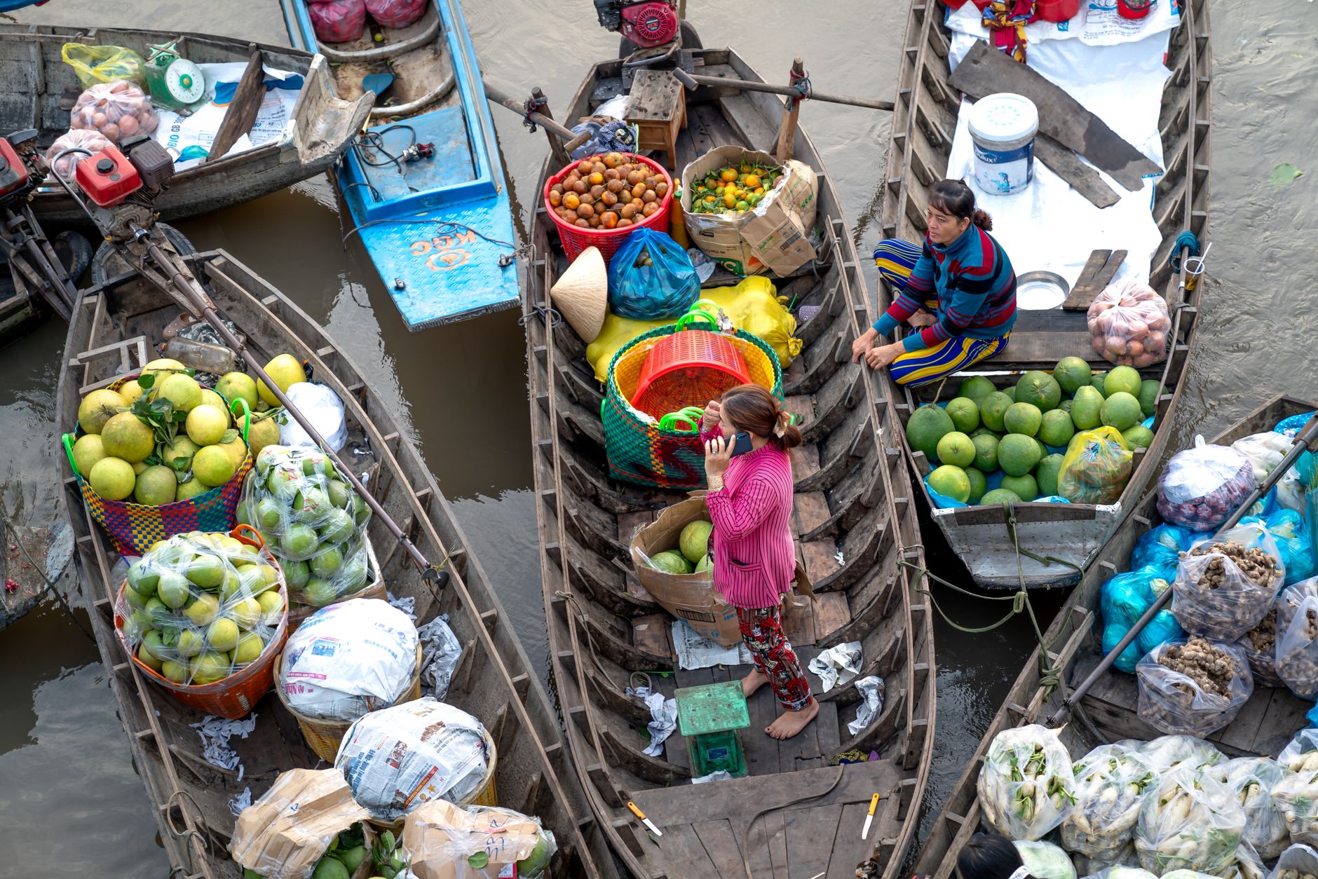 Eine lebhafte Szene eines geschäftigen schwimmenden Marktes in Vietnam, die frisches Obst und die lokale Kultur zeigt.