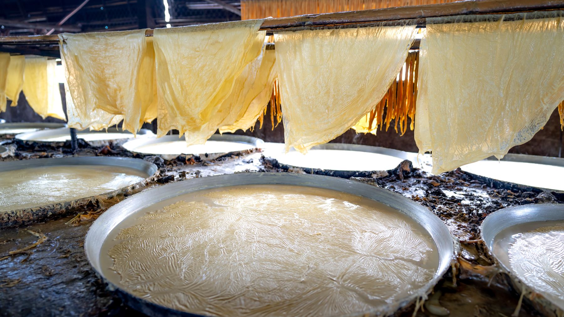 Close-up of rice paper sheets drying indoors, showcasing Vietnamese cuisine preparation.