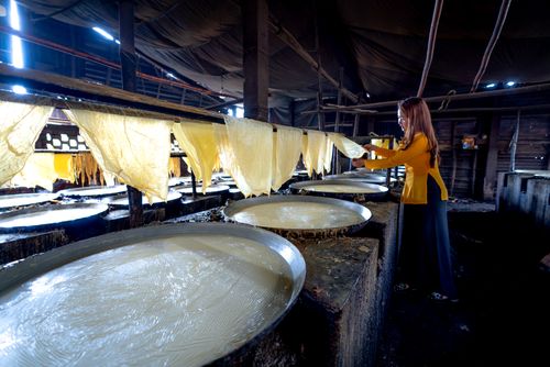 Free Asian woman preparing traditional rice paper in a Vietnamese factory. Stock Photo