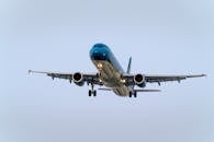 An Airplane Flying Under Blue Sky