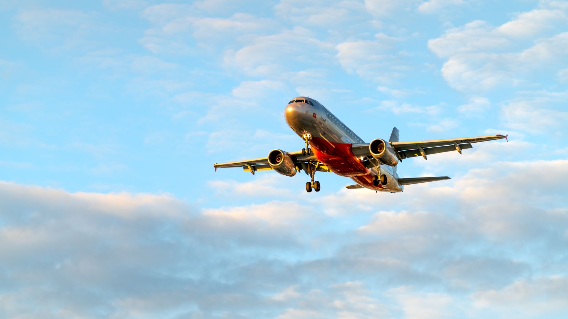 Modafinil for Jet Lag Recovery: A Comprehensive Guide A low-angle view of a passenger airplane flying amidst clouds in a clear blue sky — modafinil for jet lag recovery
