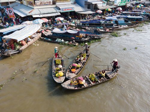 Free Traditional floating market with boats on a river in Vietnam, bustling with activity and vendors. Stock Photo