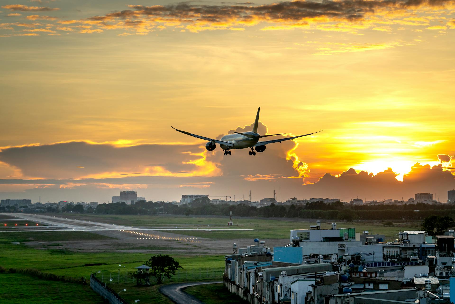 Plane soaring over clouds at golden hour