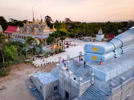Aerial image of Som Rong Pagoda and giant reclining Buddha statue during sunset.