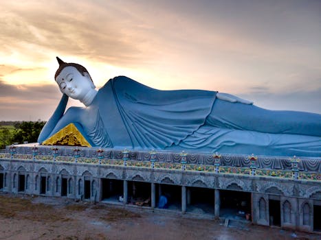 A remarkable aerial shot of the giant reclining Buddha statue at Som Rong Pagoda during sunset.