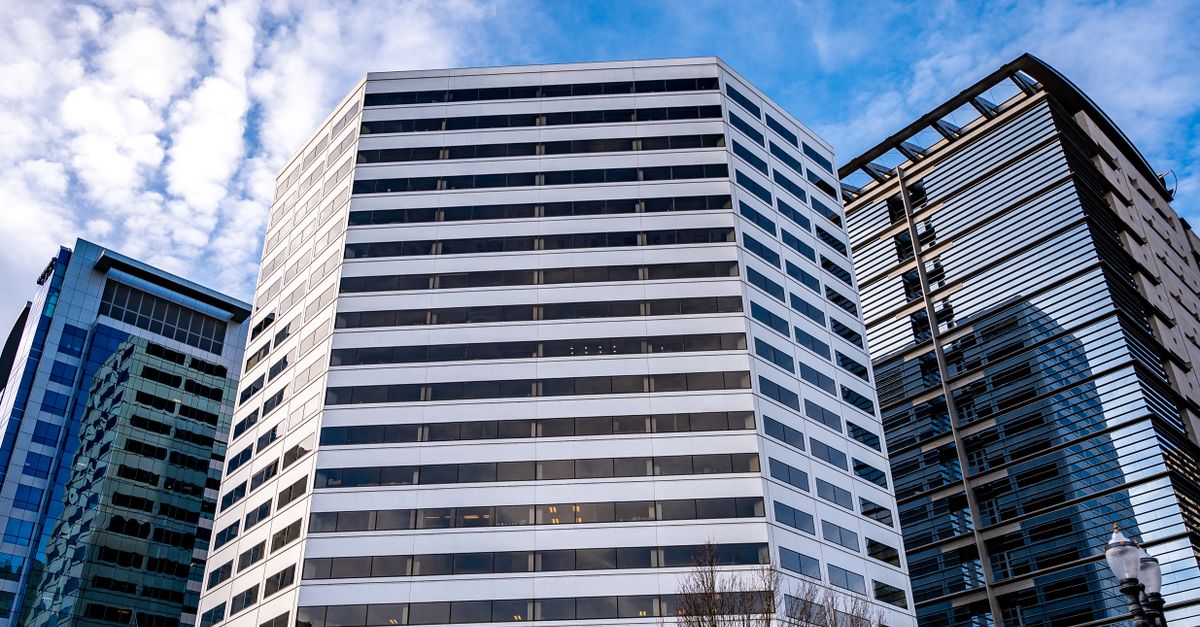 Low angle view of contemporary office buildings with blue sky and clouds in the background.