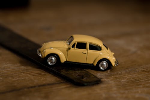 Yellow Beetle Toy Car on Wooden Surface