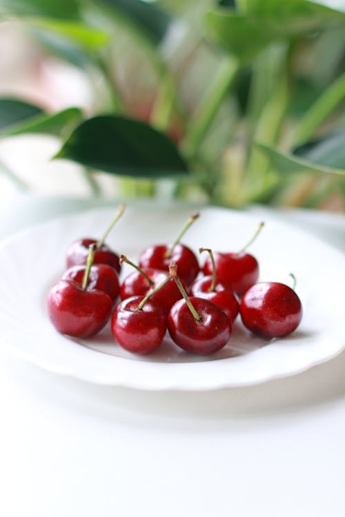 Close-Up Shot of Fresh Cherries on White Ceramic Plate