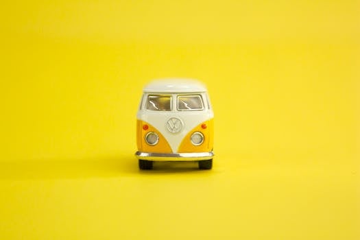 Classic Volkswagen bus scale model with a vibrant yellow backdrop, embodying retro charm.