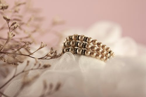 Free A Pearl Bracelet on White Textile Stock Photo