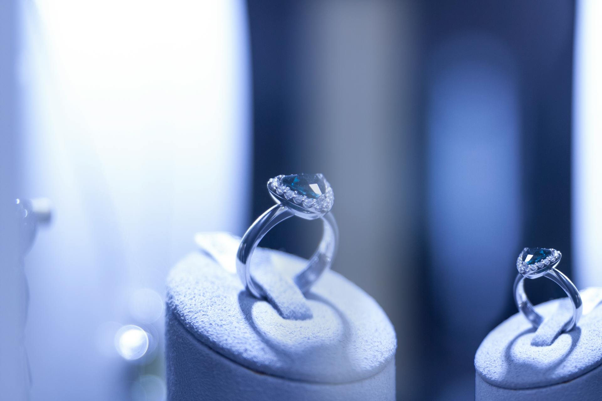 Close-up of luxury silver rings with blue gemstones on display, showcasing elegance and beauty.