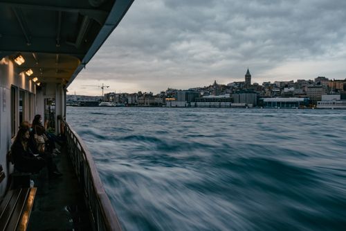Free Long exposure of a ferry with passengers, showcasing Istanbul skyline and cloudy skies. Stock Photo